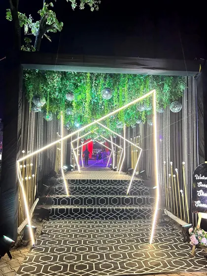 Another view of the geometric neon tunnel, showing the hanging greenery and disco balls that add a touch of disco-glam to the modern design.
