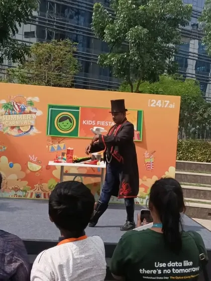 Performing a sleight-of-hand trick for the audience at the 24/7.ai Kids Fiesta. Even from a distance, the magic is clear and captivating.
