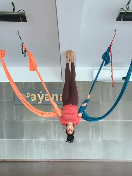 An instructor plays with two colorful hammocks, showing the vibrant and creative side of our practice.