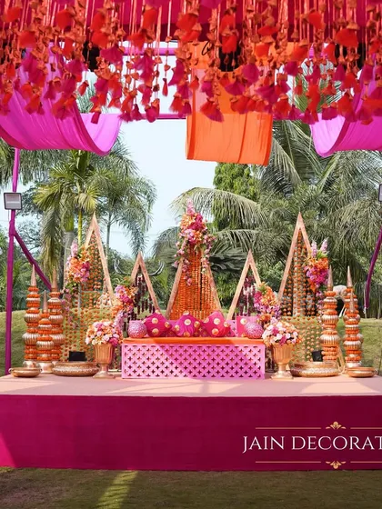 The main stage for a vibrant pink and orange themed event. The setup is rich with floral details and traditional motifs, creating a perfect focal point for the ceremony's main rituals.