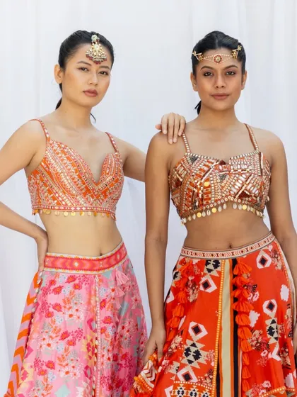 Another two model shot, this time with a tighter crop to focus on the details of the blouses. This type of image is effective for showing intricate beadwork, embroidery, and different neckline styles within a collection.
