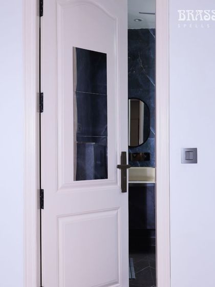 The Natali handle on a bathroom door, demonstrating its suitability for every room in the house. The consistent use of this hardware creates a polished and intentionally designed interior.