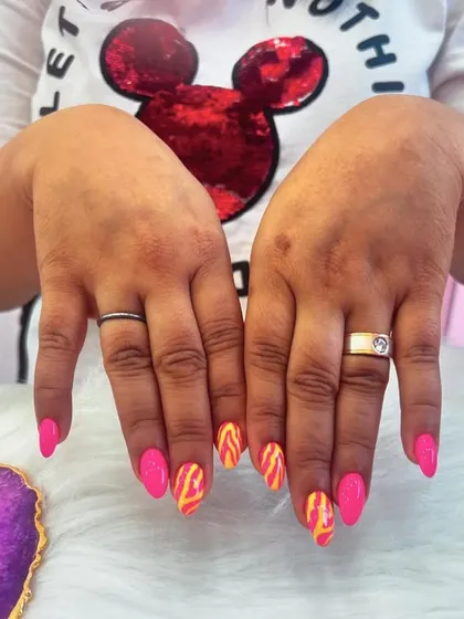 A vibrant set with hot pink nails and accent nails featuring a fiery orange and yellow flame design.