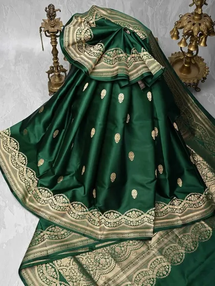 I believe the richness of a saree is in its weave. This emerald green Banarasi silk saree is a perfect example, with delicate gold butis scattered across the body and an intricately woven paisley border. It’s a classic piece that radiates opulence.