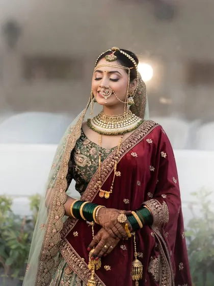 A stunning portrait of a bride in her wedding lehenga, her eyes closed in a moment of serene happiness, with her bridal mehendi adding to her grace.