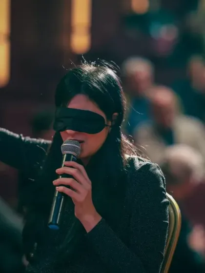Reaching out to the audience during my blindfold performance. It's all about creating a connection with everyone in the room, making them part of the experiment.