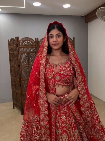 A close-up on the exquisite blouse and dupatta of this pre-loved red bridal lehenga. The detailed zardozi and thread work are what make these outfits so special.