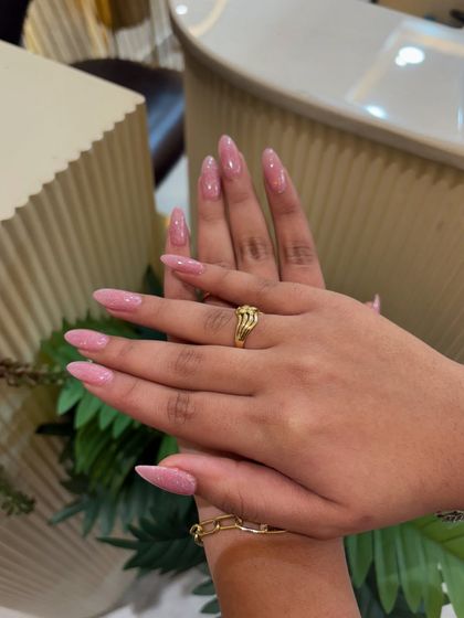 The almond shape and soft pink glitter combine for a look that is both elegant and feminine.