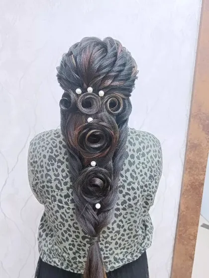 Showcasing my skill in creative hairstyling, this look features intricately sculpted hair roses within a braid. This unique, artistic style is for the client who wants a true statement piece for their event.