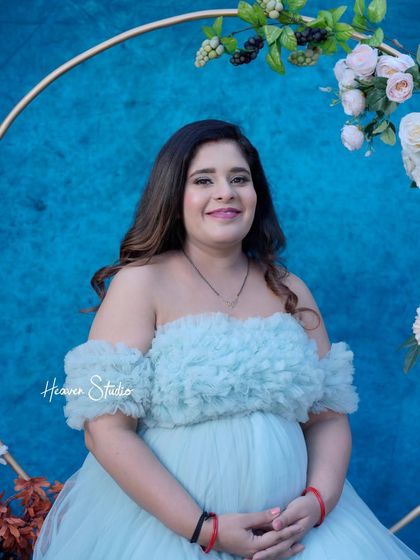A happy and confident portrait of the mother-to-be. Her bright smile radiates joy in this lovely blue-themed studio setup.