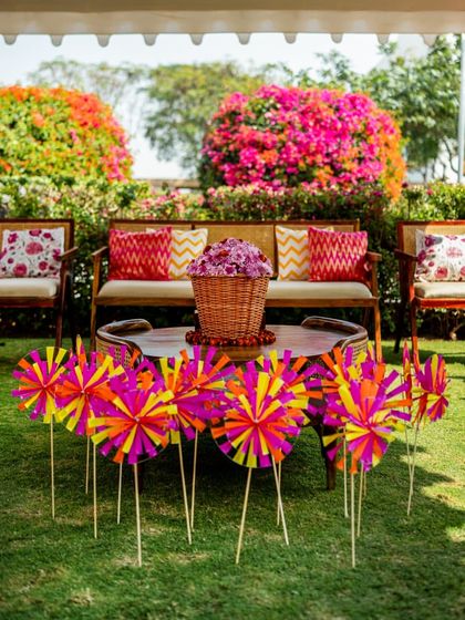A seating area perfectly framed by blooming bougainvillea bushes, with colorful pinwheels in the foreground.