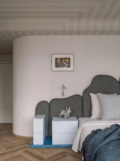 A detail shot of the master bedroom, showing the whimsical headboard and a small, colorful sculpture of a French Bulldog, a nod to the home's furry residents.