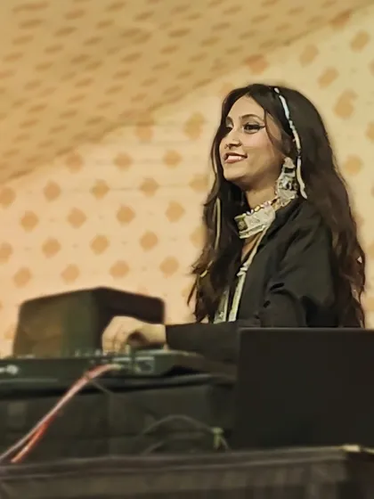 A profile shot of me at the console during the Navsari event, focused on the mix but still smiling.
