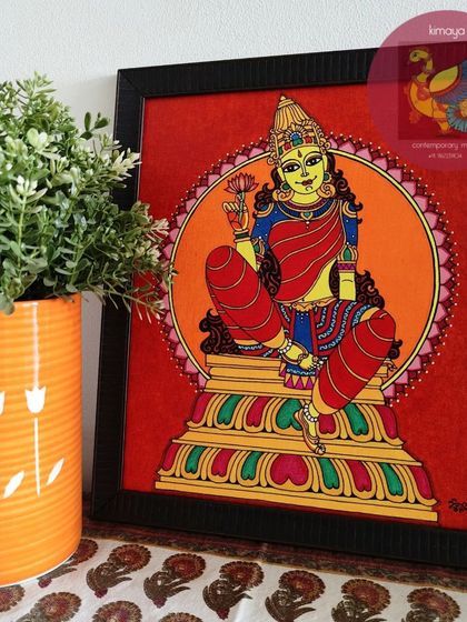 A beautiful painting of Devi, or the Goddess, seated on her throne holding a lotus. This 12x14 inch framed piece is perfect for a personal altar or a quiet corner, radiating grace and serenity.