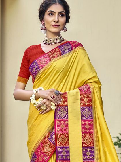A vibrant yellow Dupion silk saree with a contrasting red border. This traditional saree is perfect for bringing a ray of sunshine to any celebration.