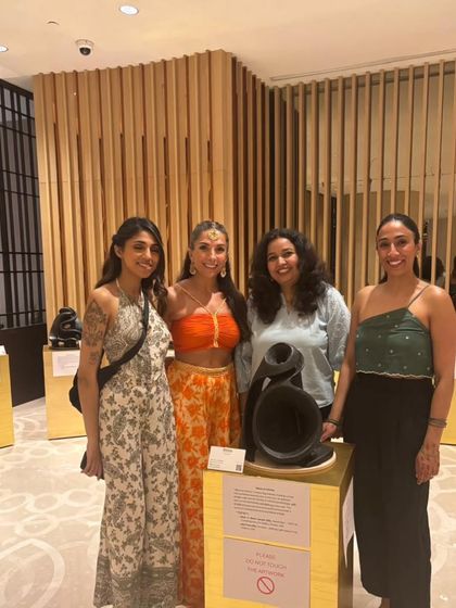 Guests posing with one of the unique sound-inspired sculptures at the 'Rhythm of Emotions' exhibition.