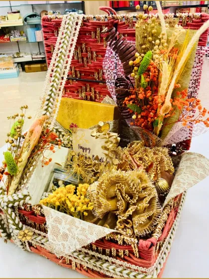 Our red woven trunk is a luxurious choice for Rakhi. It's filled with an assortment of goodies, including almond waffles and decorative items, all beautifully arranged for a grand presentation.