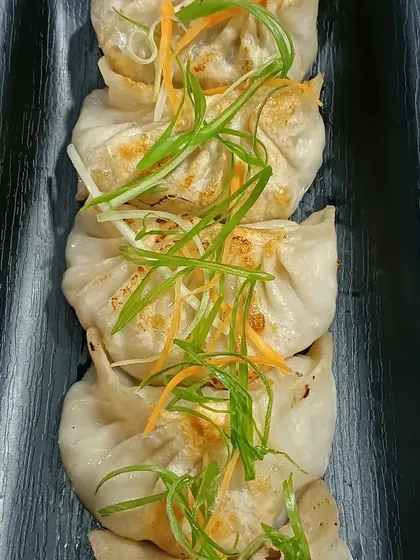 My pork momos are pan-fried until the bottom is crisp and the filling is juicy. They are served hot and are a popular choice for a quick and satisfying meal.