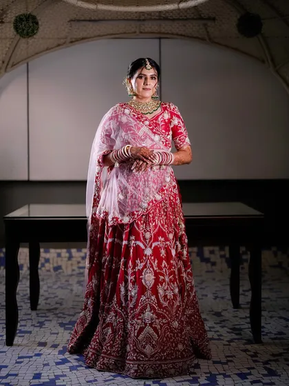A full-length portrait of the Gujarati bride in her stunning red and white lehenga.