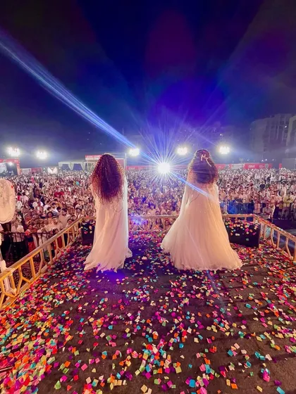 This is the magic of Navratri. A shot from behind us, looking out at the massive, packed ground. The lights, the confetti, and the thousands of people create an unforgettable atmosphere.