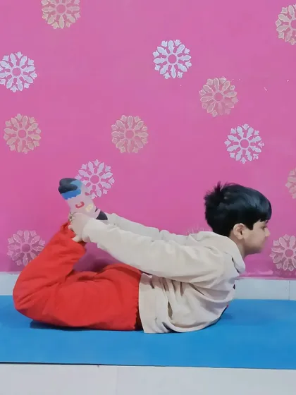 Guiding my student through the Bow Pose (Dhanurasana) to improve flexibility and strengthen his back.