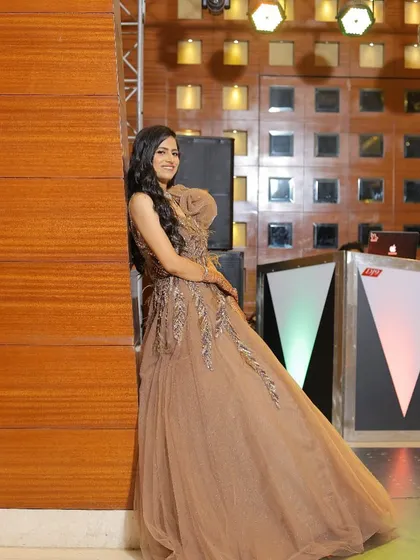 A candid moment captured perfectly. Our client looks graceful in this beige tulle gown with silver embellishments, a fantastic choice for an elegant evening affair.