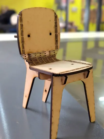 From a digital file to a physical object. This miniature chair was designed on a computer and precisely cut using our laser cutter, showcasing how we blend modern technology with hands-on assembly in our digital fabrication workshops.