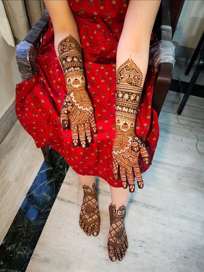 A full view showing the bride's intricate hand and feet henna, creating a complete and cohesive bridal look.