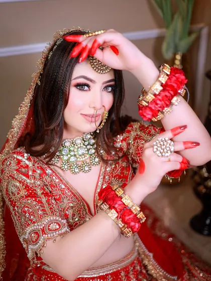 A creative pose focusing on the hands, nails, and traditional bangles, adding a touch of drama to the bridal shoot.
