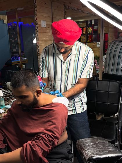A client getting a neck tattoo. I make sure to guide my clients on placement for the best aesthetic results.
