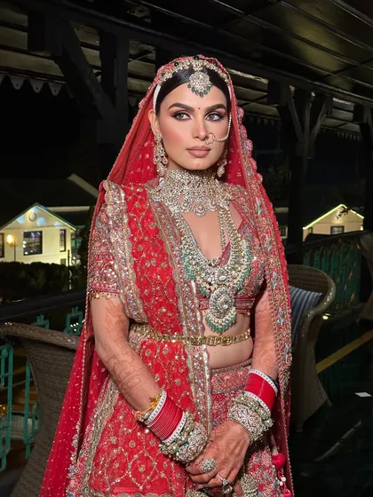 Another full-length shot capturing the grandeur of the occasion. The makeup ensures the bride is the star of the show.