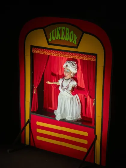Welcome to the 'Jukebox', a high-energy cabaret show from Italy. This performance is a feast for the eyes, featuring vibrant dolls and surreal characters in a classic puppet booth, promising a delightful experience filled with music and song.