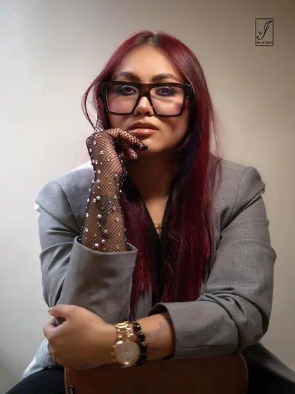 A direct and engaging portrait that combines a professional blazer with edgy, fashionable details.