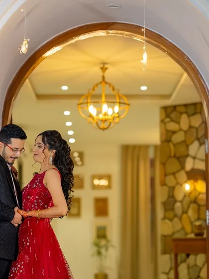 Framed in a beautifully lit archway, this shot feels like the beginning of a fairytale. The warm indoor lighting contrasts with the night outside, creating a cozy and romantic pre-wedding photo.