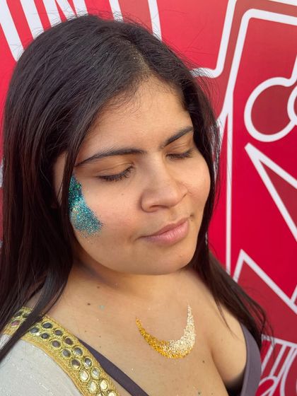 A two-part look with a teal glitter design on the face and a gold crescent on the chest. I love creating coordinated face and body art.