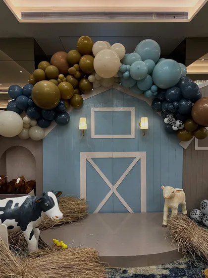 The centerpiece of the farm party was this custom-built barn facade, complete with sconce lighting and an organic balloon garland in earthy tones.