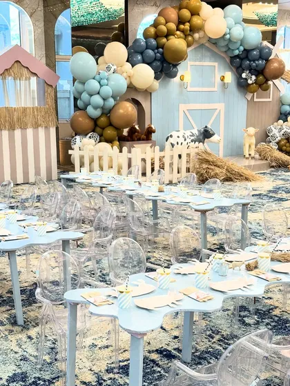An overview of the kids' dining area at the farm party, with cloud-shaped tables, ghost chairs, and the main barn backdrop creating a cohesive and fun atmosphere.