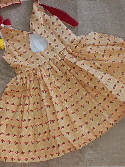 Another beautiful frock made from fabric I personally selected. The small floral print and red shoulder ties create a charming, rustic look perfect for garden adventures.