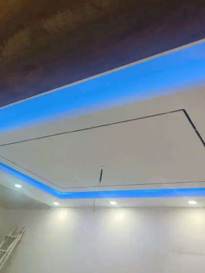 A close-up of a living room ceiling design with blue cove lighting. This creates a dramatic and modern effect, perfect for entertainment areas.