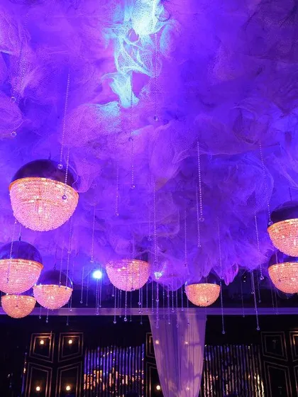 A celestial-themed reception ceiling decor at The Oberoi, Gurgaon. The design features a dreamy cloud-like installation with hanging spherical crystal lights, creating a magical, starry night effect.