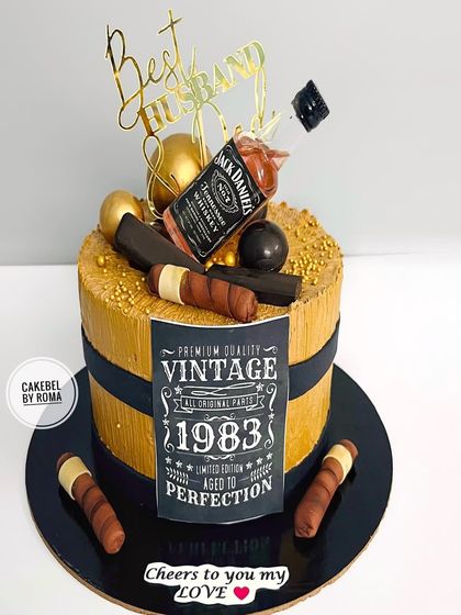 Cheers to the "Best Husband Ever." This vintage-themed cake is perfect for a milestone birthday, featuring a miniature Jack Daniels bottle, edible cigars, and a "Aged to Perfection" label.