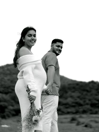 A classic black and white portrait of the couple walking hand-in-hand. Her joyful glance back at the camera captures the happiness of the moment.