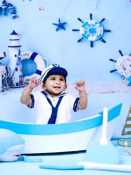 A wide shot of the sailor-themed setup, showing the baby's joyful expression.