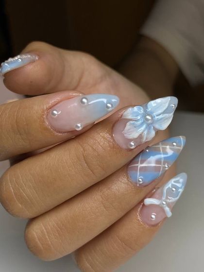 A side view of our intricate 3D nail art, highlighting the dimension of the sculpted bows and the delicate placement of each pearl bead on these long, stiletto-shaped nails.