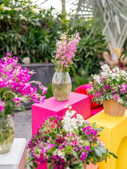 Close-up of floral arrangements in bright pinks and yellows, adding a burst of color to the Haldi decor.