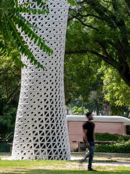 A person walks past the VERTO tower, giving a sense of its scale and its non-intrusive presence in a public thoroughfare.
