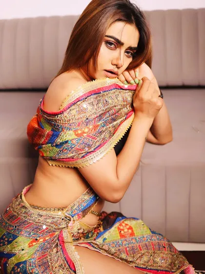 An intimate portrait of a model in a colorful, modern-style saree, showcasing a soft and glamorous look.