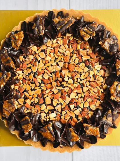 For the ultimate chocolate and nut lover, I present my dark chocolate and almond praline tart. It features a silky dark chocolate ganache filling, generously topped with crunchy roasted almonds and chunks of homemade almond praline.