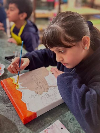 The first layers of color being applied to a canvas for our "Project Mexico" church painting. Students begin with a sketch and carefully build up their composition.