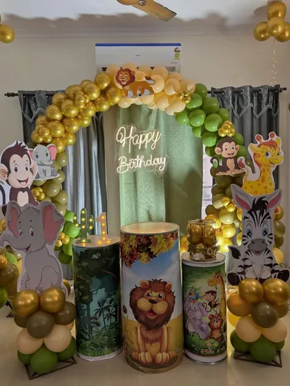 A closer look at the Jungle theme backdrop with a neon sign and themed plinths for the cake and desserts.